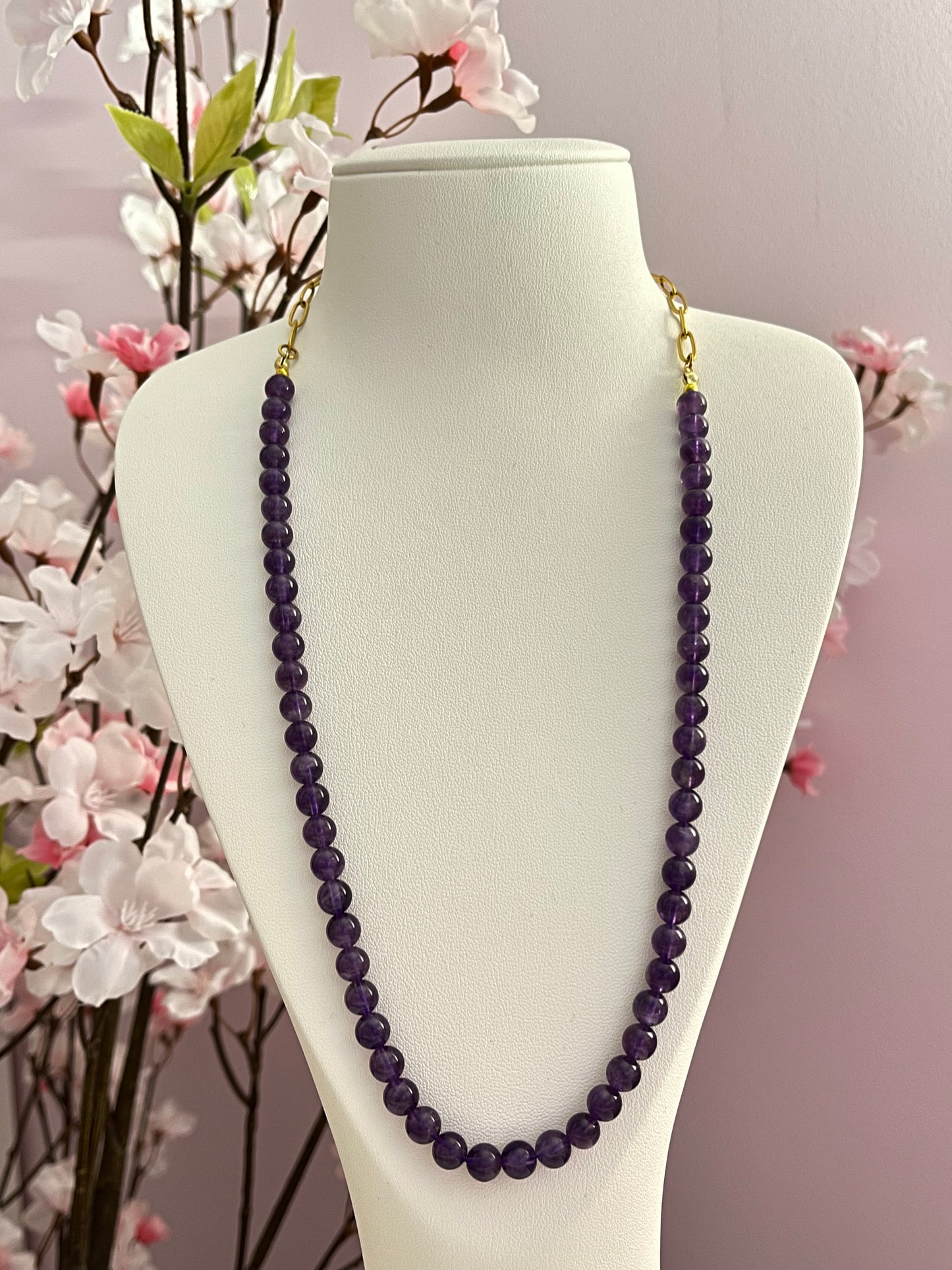 Collier long, type sautoir, chaine de maillons originaux et dorés dans la nuque, et belle longueur de perles rondes d'améthyste, pierre naturelle qui aiderait à apaiser l'esprit, favoriser l'intuition, retrouver calme, clarté, sérénité intérieure.
