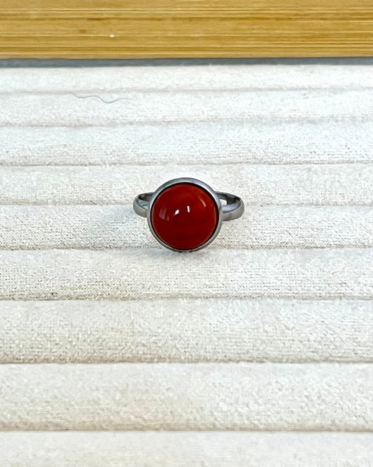 bague simple et épurée en inox argent, surmontée d'une pierre de jaspe rouge. Ajustable, pour convenir aux doigts fins comme aux doigts gros.