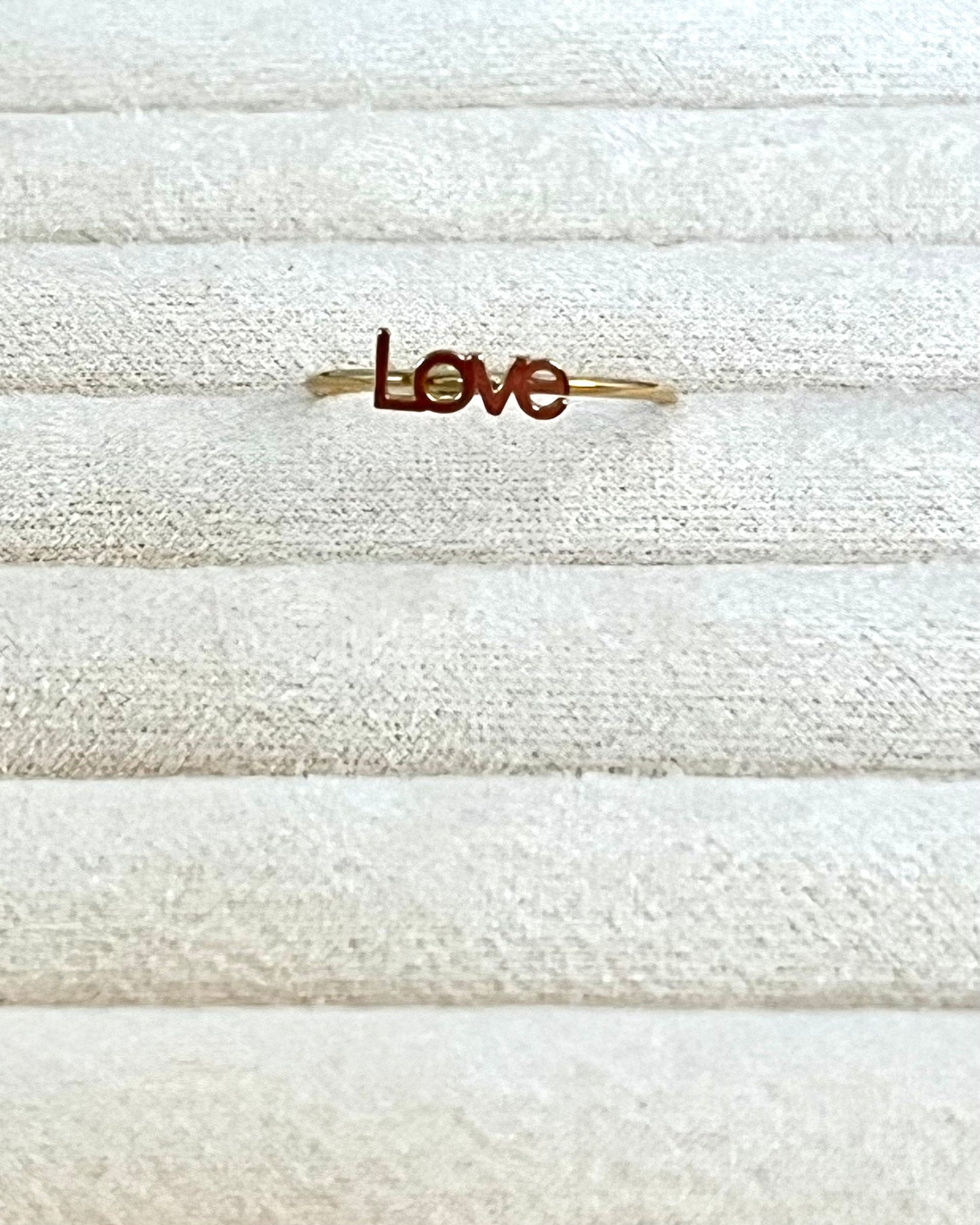 Le mot "love" appliqué sur un anneau minimaliste, simple, épuré, authentique, l'essentiel
