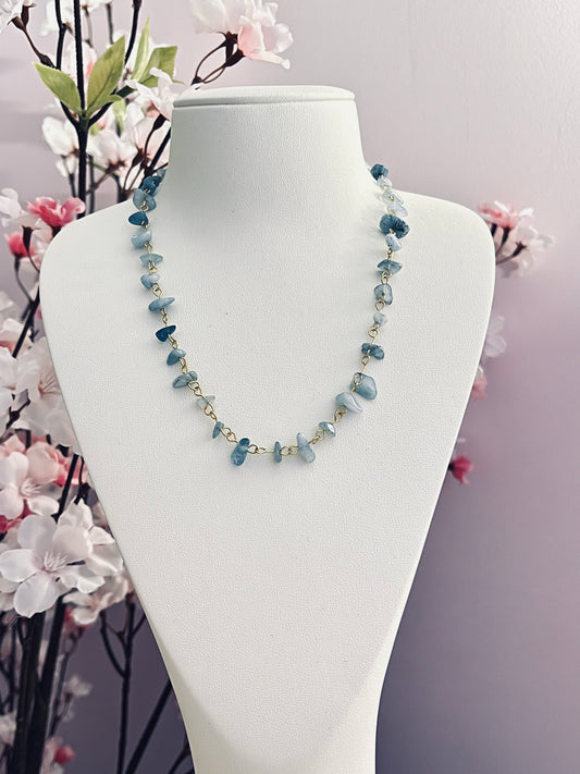 Joli collier tout mignon, composé de maillons de chaine dorée, et de perles chips de pierre naturelle d'aigue-marine, qui est réputée pour apaiser les émotions, faciliter une communication douce, et aider à exprimer sa vérité avec sérénité. Jolies variations de tons entre les perles.