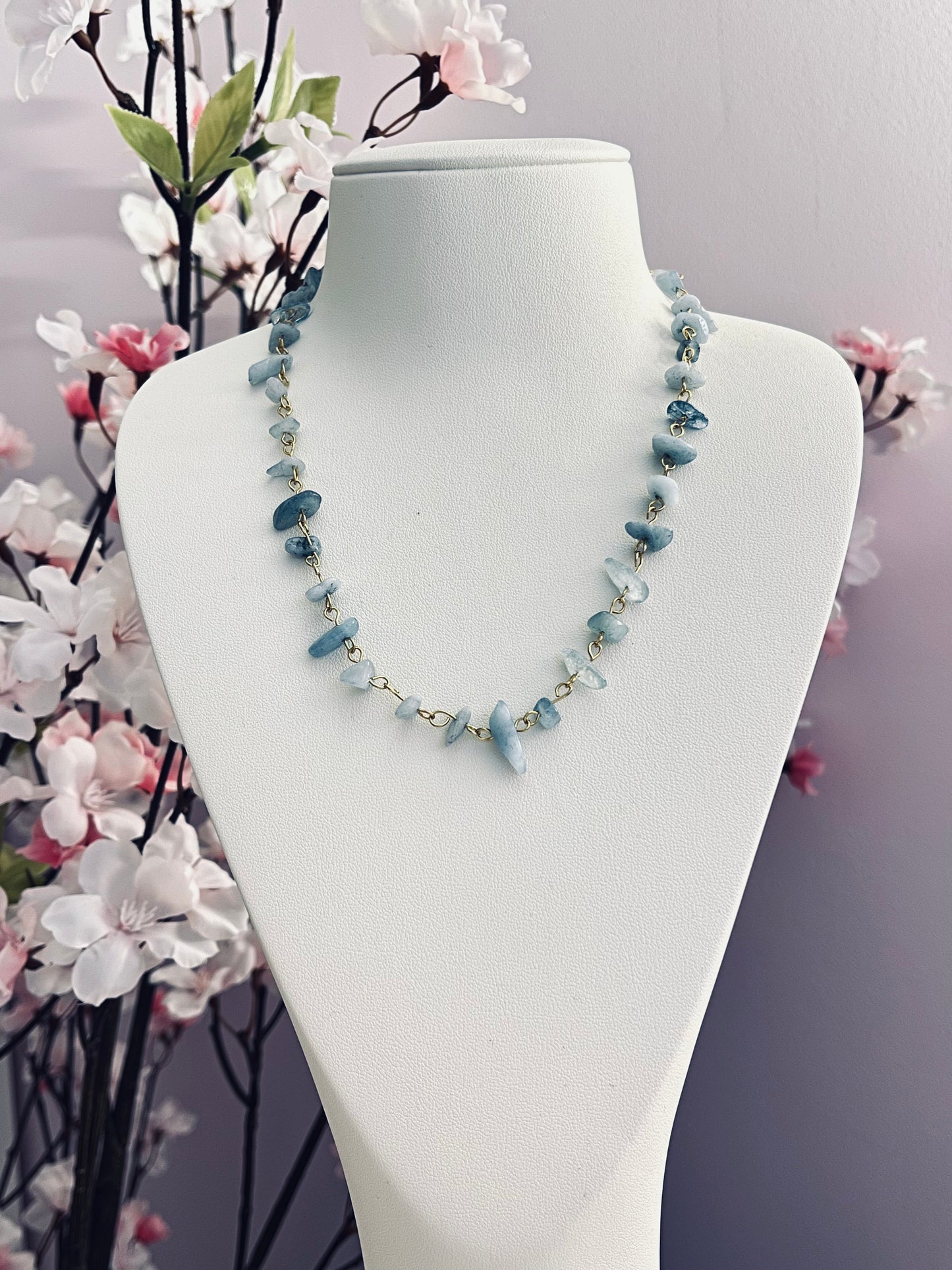 Joli collier tout mignon, composé de maillons de chaine dorée, et de perles chips de pierre naturelle d'aigue-marine, qui est réputée pour apaiser les émotions, faciliter une communication douce, et aider à exprimer sa vérité avec sérénité. Jolies variations de tons entre les perles.